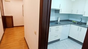 Eine Küche mit weißen Schränken, einem Spülbecken und einer Arbeitsplatte.
