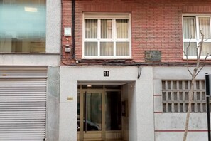 Een gebouwde ingang met glazen deur, een bakstenen gevel en het cijfer '11' boven de deur.