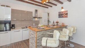 Une cuisine moderne dotée d’un îlot central, de tabourets de bar et d’un coin repas.