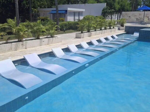 Relax by the pool surrounded by palm trees and a minimalist design.