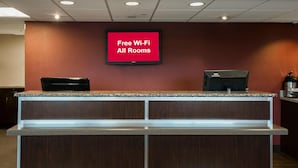 Un comptoir d’accueil doté d’un écran numérique affichant la mention : « Wi-Fi gratuit dans toutes les chambres ».