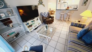 Un soggiorno con TV, divano, tavolino da caffè e una zona pranzo sullo sfondo.