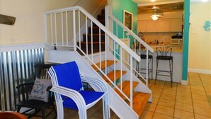 A staircase with white railings leading to a kitchen area. - K7 Family Friendly, make some memories,clean, easy 2 bdrm 1.5 bath (St. Simons Island)