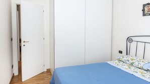 Una camera da letto con un letto, una porta e una lampada fissata al muro.