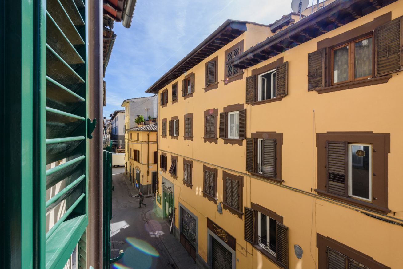 Eine enge Straße mit Gebäuden im traditionellen Baustil und Fensterläden.
