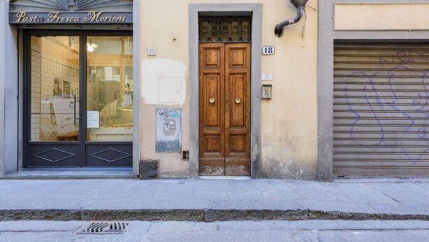 A building facade with a storefront labeled 'Pasta Fresca Morioni,' a wooden double door, and a closed shutter to the right. - Santa Maria Novella Classic by Mmega (Firenze)