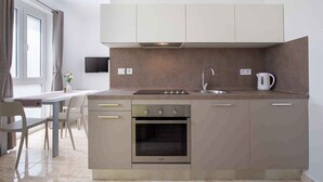 Una cocina moderna con horno empotrado, un fregadero y un hervidor.