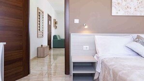 Un dormitorio con cama, mesita de noche y lámpara fijada a la pared.