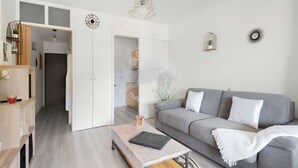 A modern living room with a grey sofa, a coffee table, and a wooden cabinet.