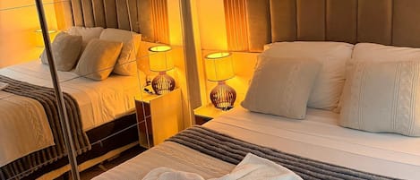 Una habitación de hotel con una cama, una mesita de noche, una lámpara y un espejo.