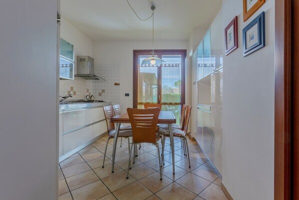 A compact kitchen with a dining area, a window, and a door leading outside. - Apartment located on the ground floor of a modern terraced house with private entrance.Beautiful private garden with table and chairs for outdoor dining or simply relaxing.In 75 square meters of space it accommodates 6 people with a double bedroom, a sin (Ferrara)
