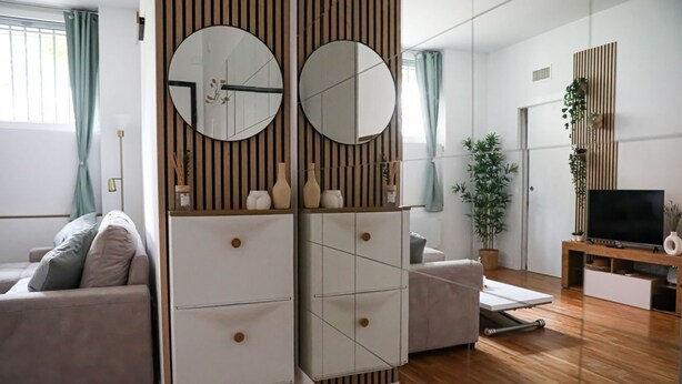Una sala de estar moderna con un sofá, un mueble para TV y un aparador con espejo.