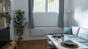 Una sala moderna con una mesa de comedor, sofá y una planta en maceta.