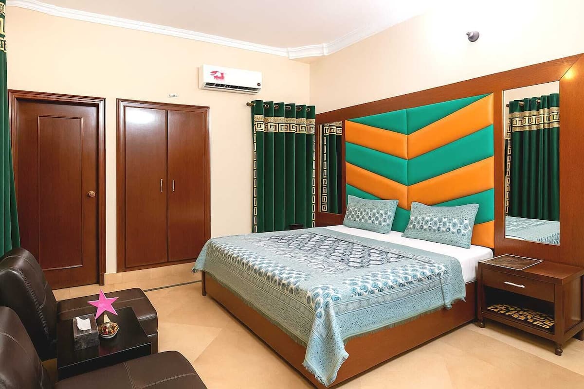 Un dormitorio con cama, armario, escritorio y silla.