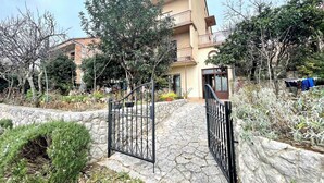 A residential building with a stone pathway leading to a gated entrance.
