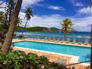 Ein Pool mit Liegestühlen und Blick auf den Ozean.