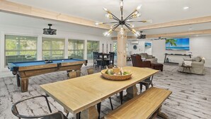 Una habitación amplia con mesa de billar, mesa de comedor y piscina.