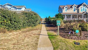 A pathway leading to a residential area with houses on both sides.