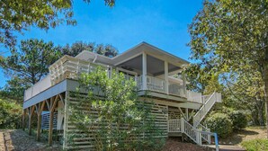 A two-story building with a covered porch and a staircase leading to the upper level.
