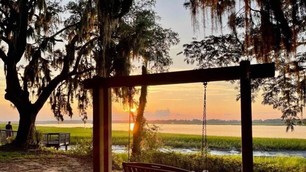 A wooden swing under a pergola with a view of a sunset over a water body. - 3 Min walk to Pigeon Point Park. Pets Yes (Beaufort)