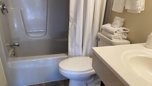 A bathroom with a bathtub, toilet, and sink.