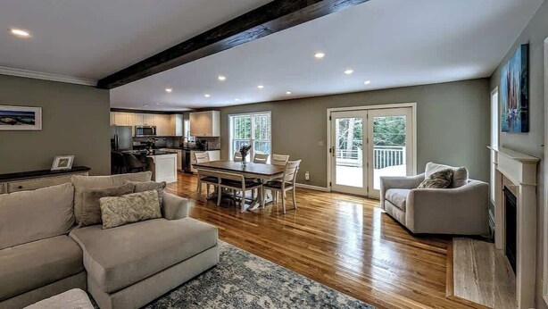 A spacious living area with a dining table, a sofa, and a fireplace. - Charming Bar Harbor Home w/ Fire Pit & Trails (Bar Harbor)