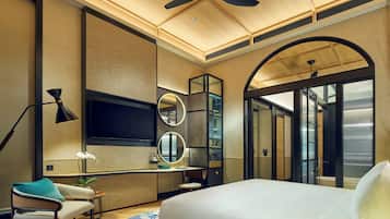 Une chambre d’hôtel moderne équipée d’un grand lit, d’un bureau, d’une chaise, d’une télévision et d’un miroir.