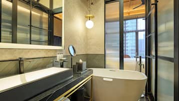 Un baño moderno con una bañera grande, un tocador doble, un espejo y un ventilador de techo.