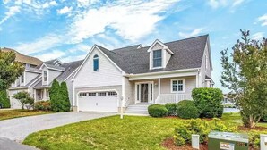 A single-story residential house with a front garage, a covered porch, and a well-maintained lawn.