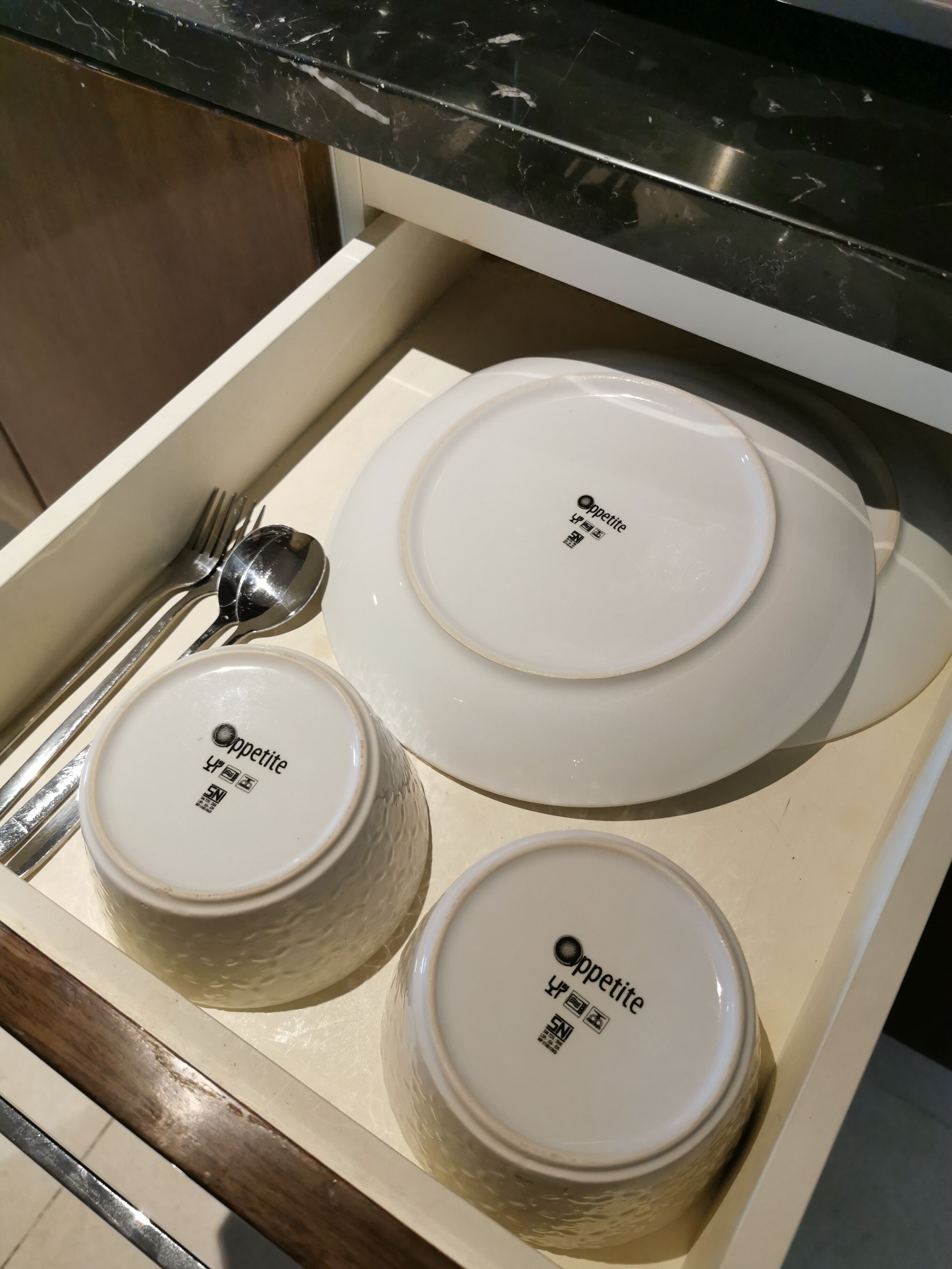 A kitchen drawer with three white ceramic containers labeled 'Oppetite' and a spoon.