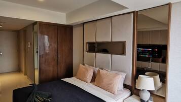 A modern bedroom with a bed, bedside table, and a wardrobe.