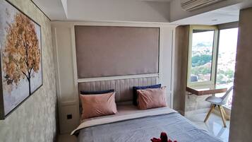 A modern bedroom with a large bed, a headboard, and a window with a view.