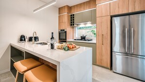 Eine moderne Küche mit Marmorarbeitsplatte, Edelstahlgeräten und Holzschränken.