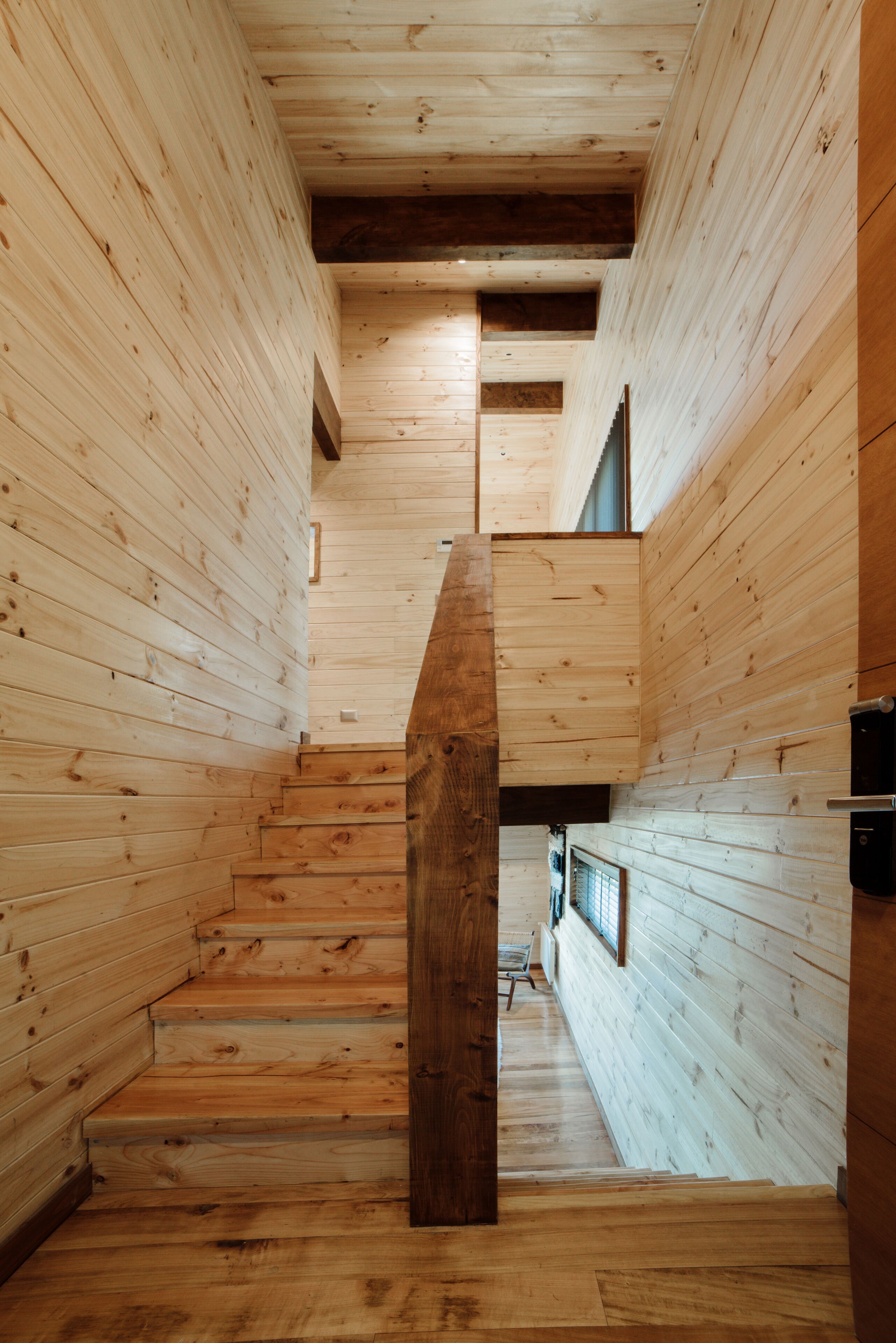 A wooden interior with a staircase leading to a higher level.