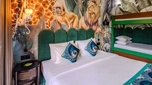 A room with a mural of animals, a bunk bed, and a desk with a lamp. - Marine Bay Sanur (Denpasar)