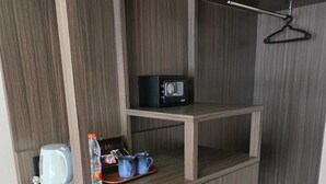 A compact kitchenette with a microwave, kettle, and refrigerator. - Marine Bay Sanur (Denpasar)
