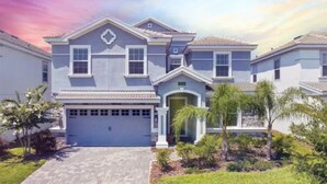 A two-story residential house with a garage, a front porch, and a landscaped yard. - Disney 8BR Villa, Pool + Hot Tub, Theater, Game Room, Themed Bedroom, Sleeps 16+ (Four Corners)