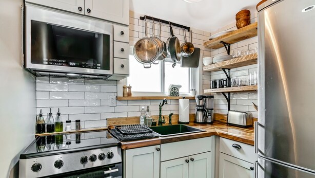 A modern kitchen with white cabinetry, stainless steel appliances, and a wooden countertop. - Cozy & Historic Gem: Free Parking+ Patio -Sleeps 6 (Philadelphia)