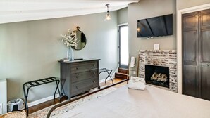 A room with a fireplace, a dresser, a mirror, and a TV mounted on the wall. - Cozy & Historic Gem: Free Parking+ Patio -Sleeps 6 (Philadelphia)