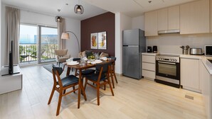A modern kitchen with a dining area, large windows, and a view of the city. - Maison Privee - Exquisite Apt on Yas Island cls to ALL attractions (Abu Dhabi)