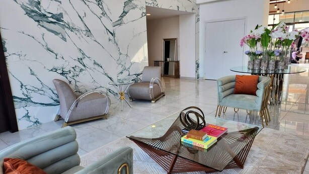 A spacious lobby with marble walls, modern seating, and a glass coffee table with books. - Elegant & Luxury Gem-5 Star Location -Pools, Gym! (Accra)