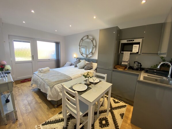 Relax in a spacious room with a large window, seating area, and kitchenette.