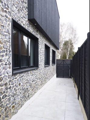 Stunning building with a flat roof and large windows, featuring a paved walkway to the entrance.