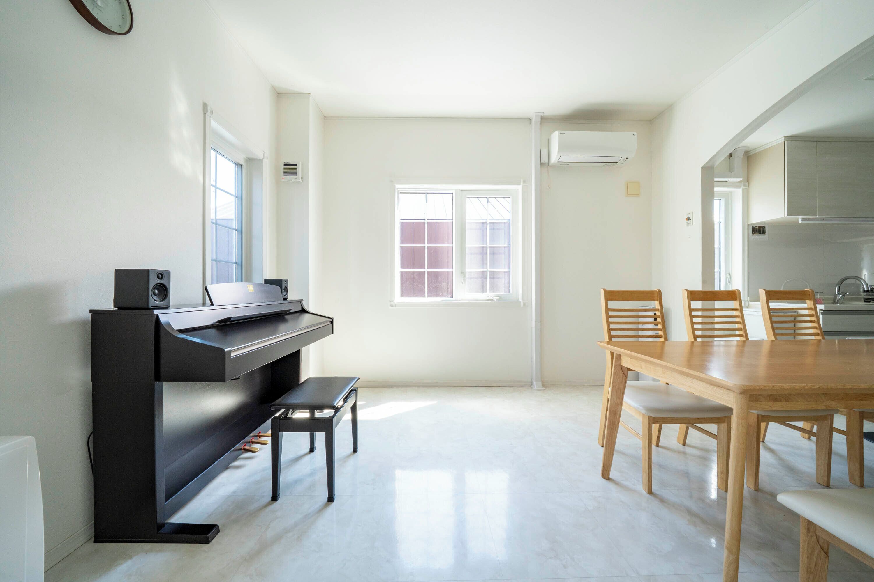 Una cucina moderna con piano cottura integrato, un tavolo da pranzo con sedie e un pianoforte.