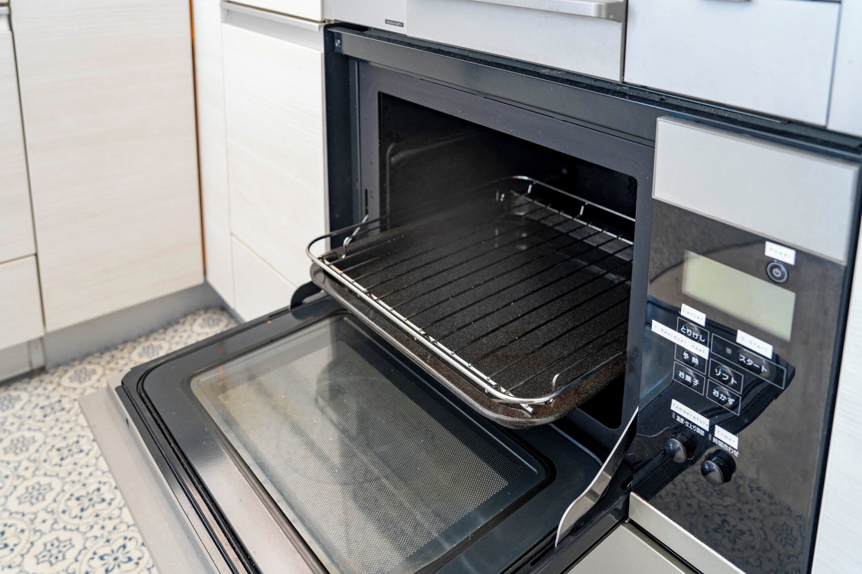 Horno abierto con panel de control digital y puerta de cristal.