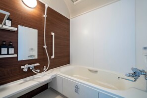 Een aparte badkuip en douche, een regendouche, een haardroger