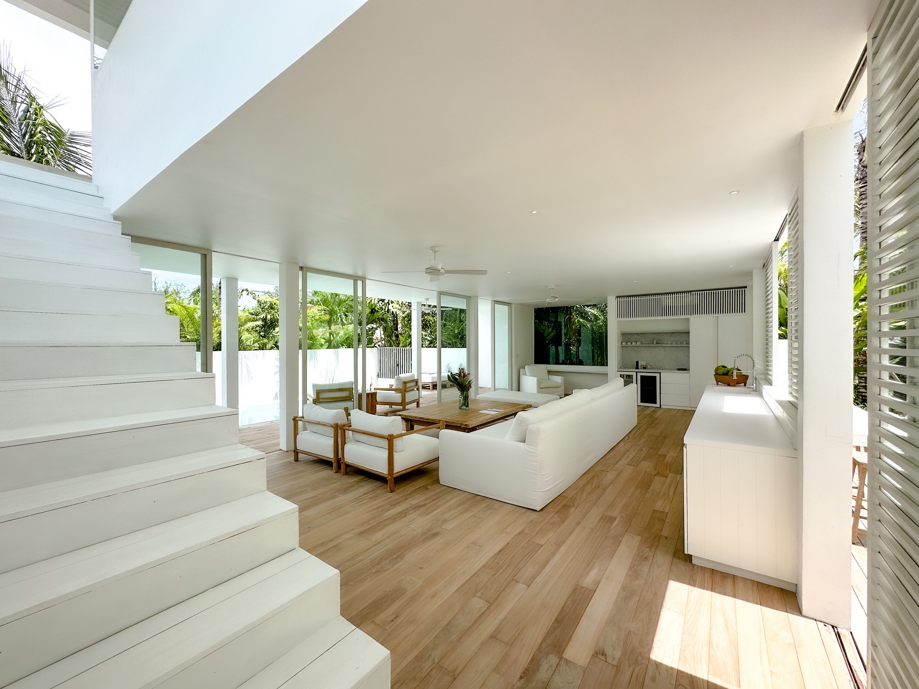 Ein modernes Interieur mit Treppe, Essbereich und Küche.