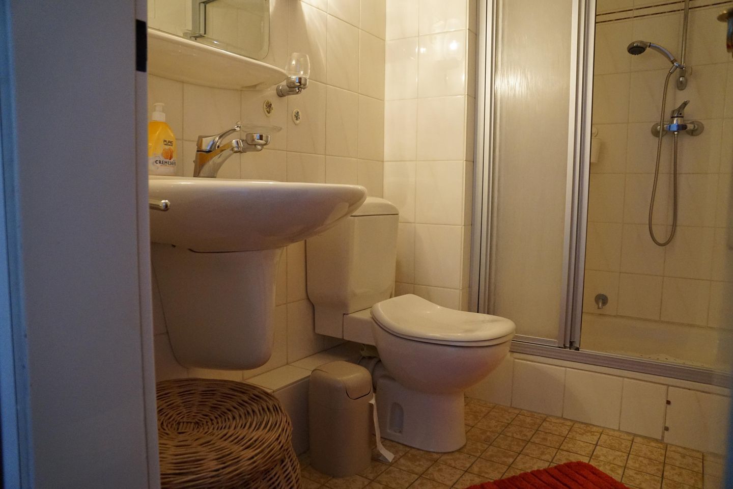 Een badkamer met toilet, wastafel en douche.