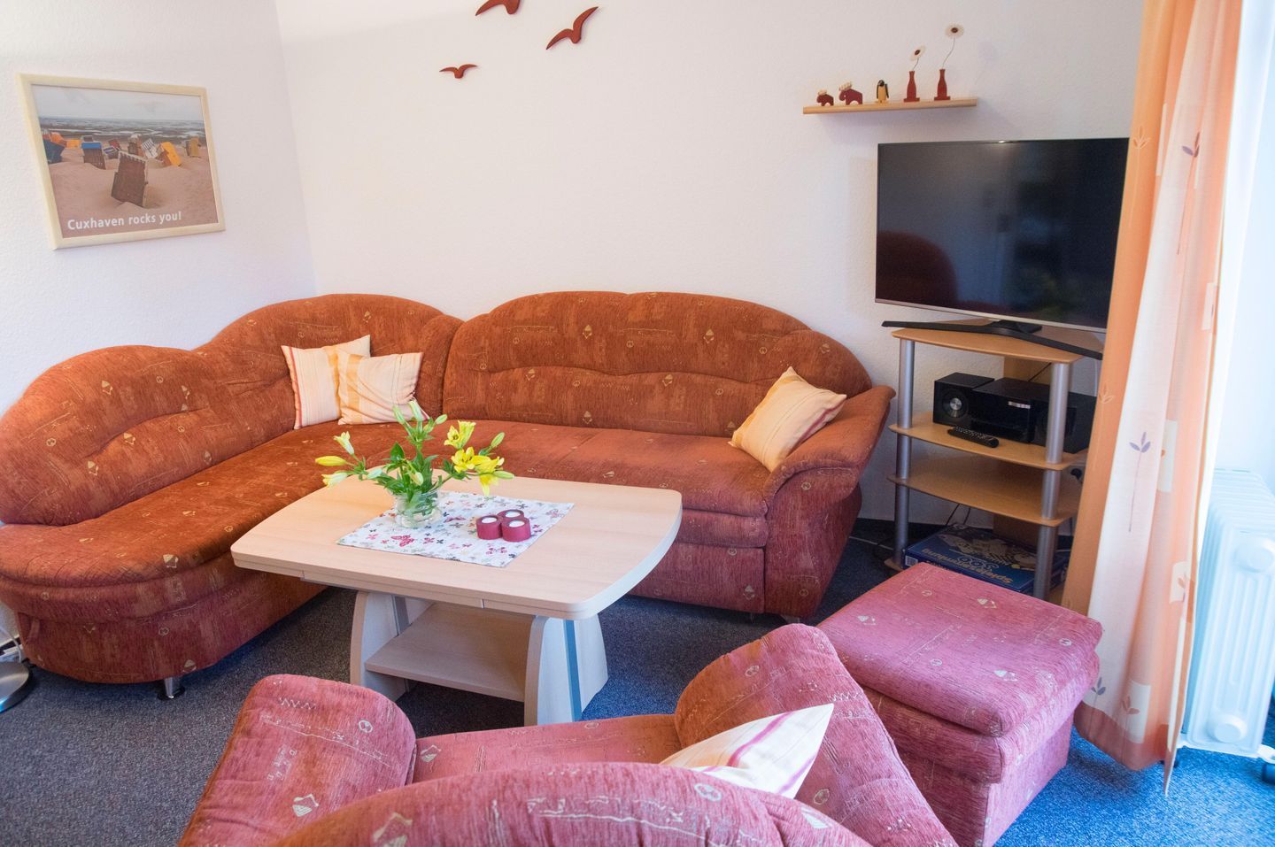 Ein Wohnzimmer mit einer Couch, einem Couchtisch und einem Fernseher.