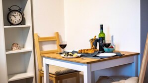 A dining table with a bottle of wine, glasses, bread, and olives.